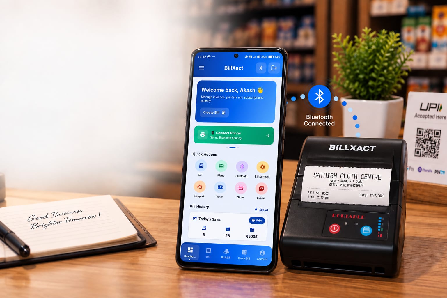 The BillXact app on an Android phone beside a BillXact Bluetooth thermal printer printing a GST bill